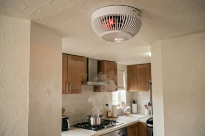 Détecteur de fumée au plafond près d'une cuisine avec vapeur montant d'une casserole